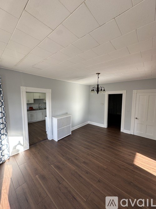 A room with wooden floors and a chandelier.
