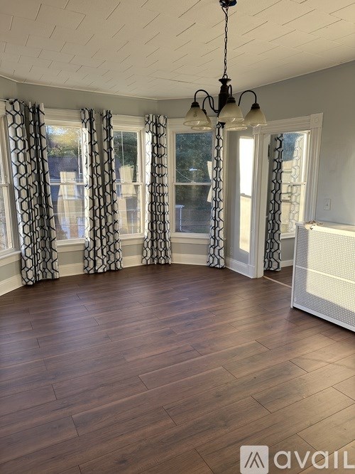 A room with wooden floors and a chandelier.