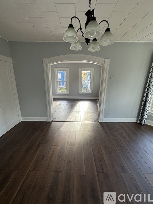 A room with wooden floors and a chandelier.