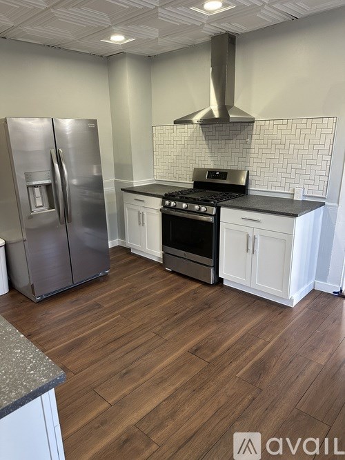 A kitchen with a stove, refrigerator, and cabinets.