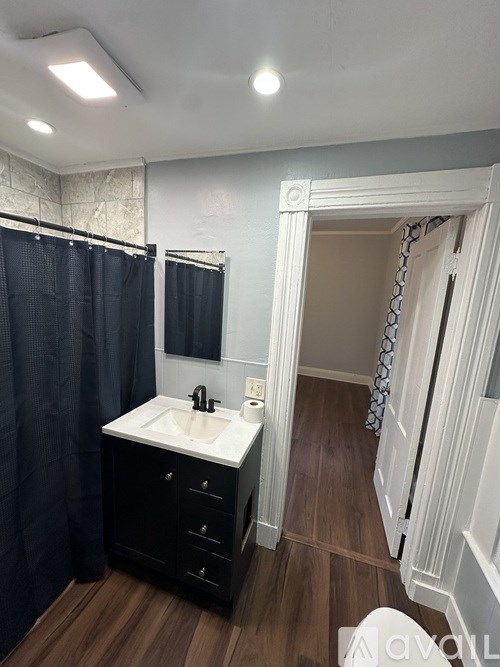 A bathroom with a sink, mirror, and shower.