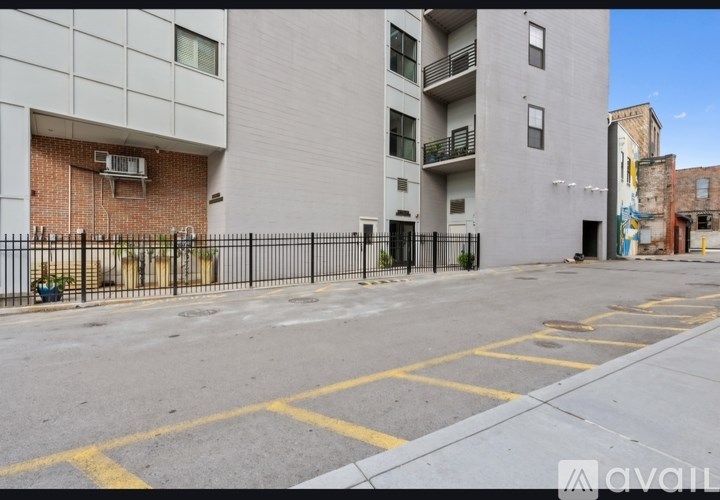 A street view of a building with a black fence and a yellow line on the road.