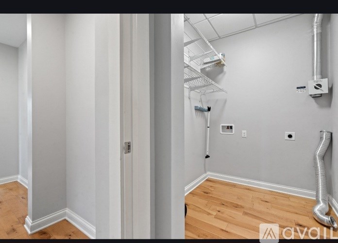 A room with a white door and a wall with a pipe.