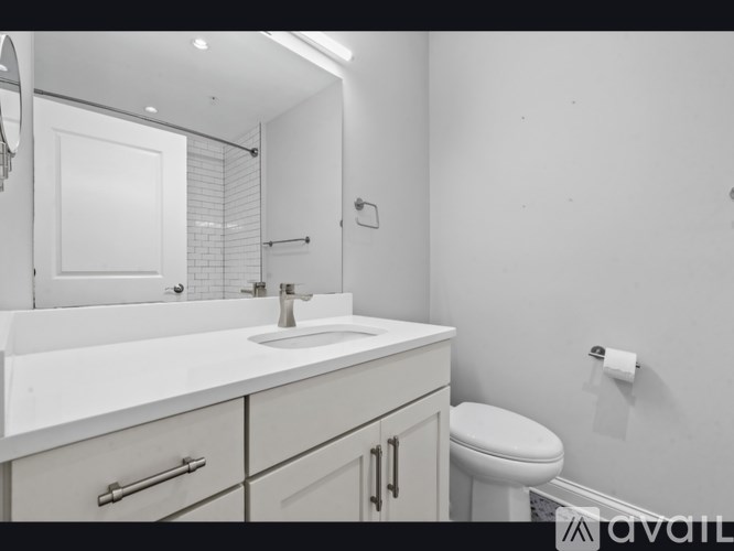 A bathroom with a white sink and toilet.