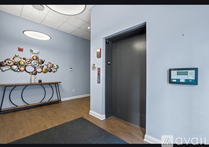 A hallway with a black door and a wall art of circles.