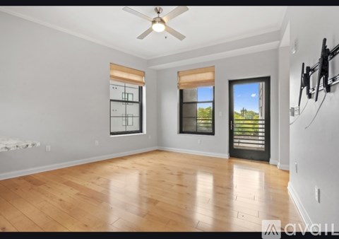 A spacious room with a ceiling fan and wooden flooring.