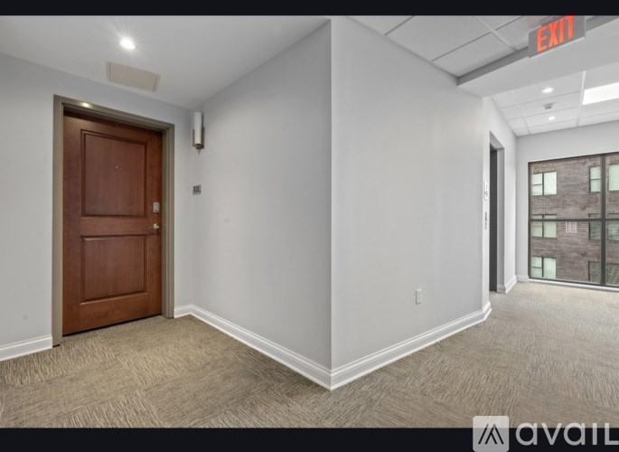 A room with a brown door and a window with a view of a building outside.