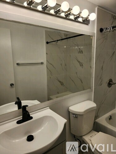 A bathroom with a white sink and toilet.