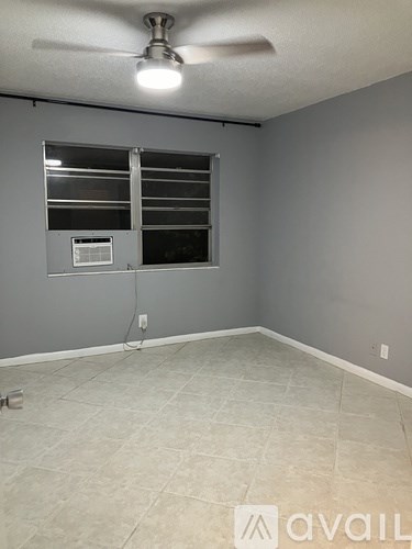 A room with a ceiling fan and a window with blinds.
