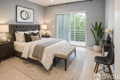 A bedroom with a large bed, a bench, and a chair.