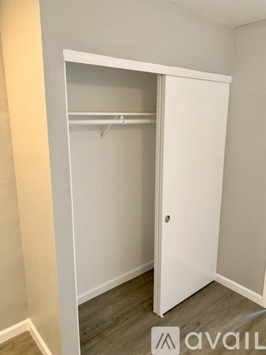 A white closet with a shelf and a door.