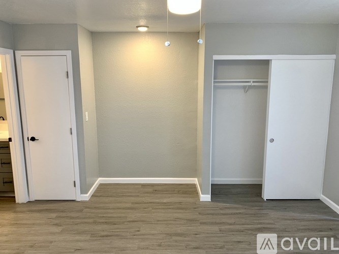 A room with a white door and a grey wall.