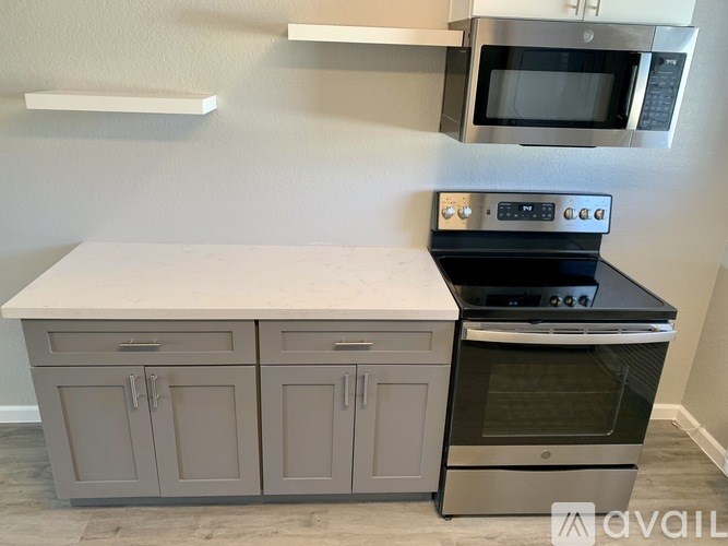 A kitchen with a white countertop and grey cabinets.