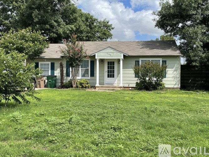 A small house with a green door and a porch.
