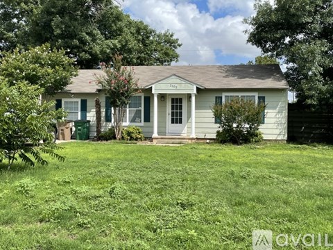 A small house with a green door and a porch.