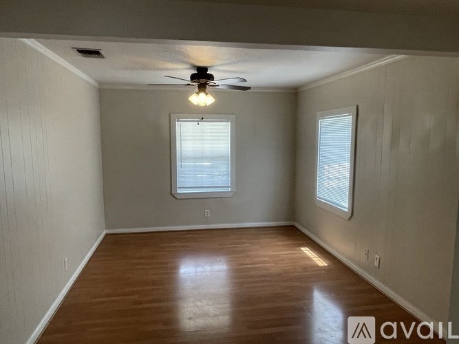 A room with wooden flooring and a ceiling fan.