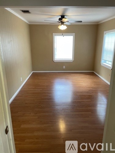 A room with wooden flooring and a ceiling fan.