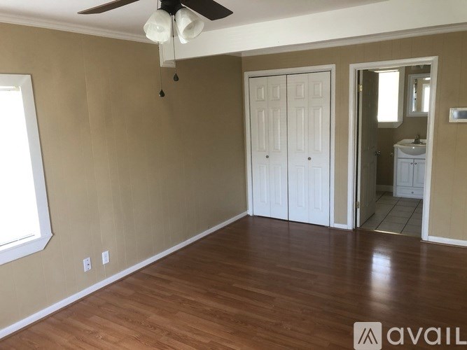 A room with a ceiling fan and two doors.