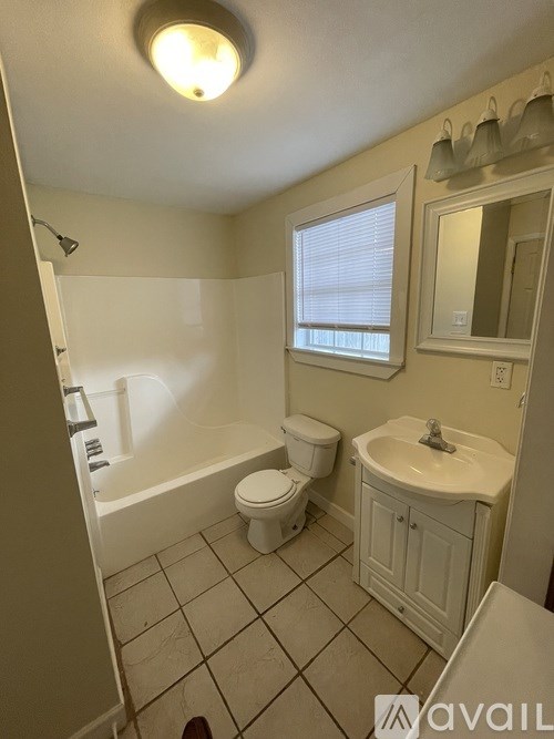 A bathroom with a toilet, sink, and bathtub.