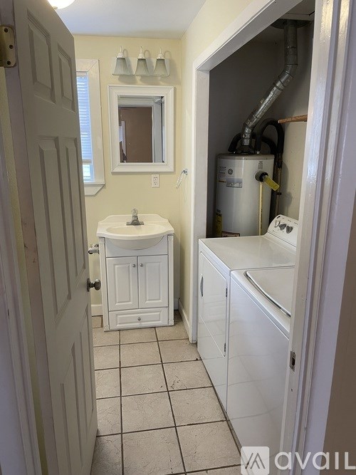 A bathroom with a toilet, sink, and a cabinet.