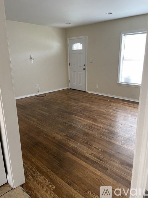 A room with wooden flooring and a white door.