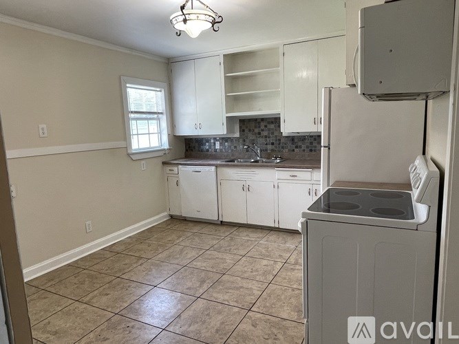 A kitchen with white cabinets and a tiled floor.