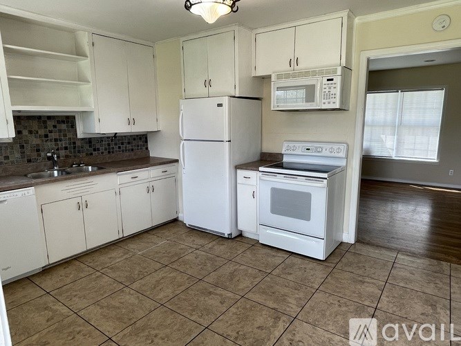 A kitchen with white appliances and cabinets.