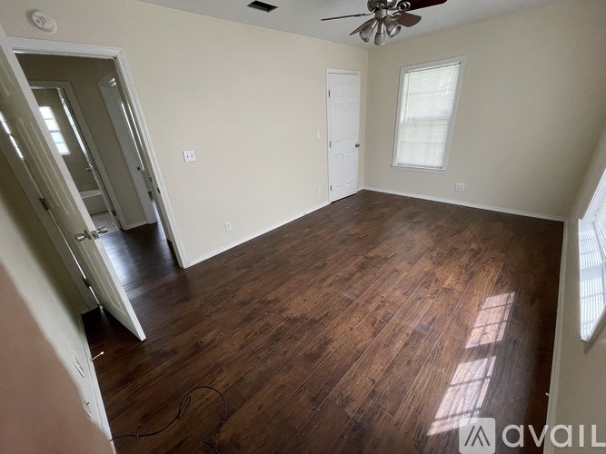 A room with wood flooring and a ceiling fan.