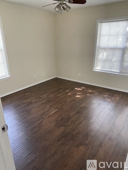 A room with wooden flooring and a ceiling fan.