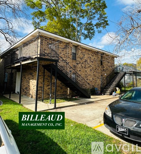 A house with a car parked in front and a sign that says "BILLEAUD MANAGEMENT CO., INC."