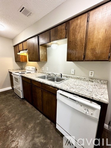 A kitchen with brown cabinets and white appliances.