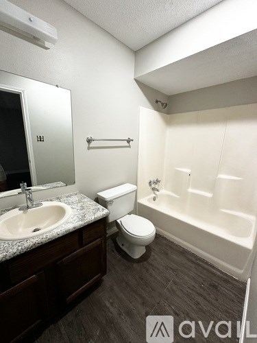 A bathroom with a toilet, sink, and bathtub.