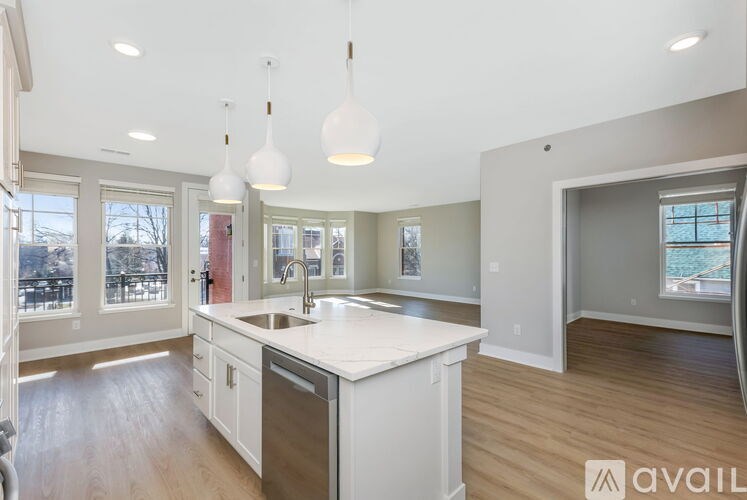 A modern kitchen with a large island and pendant lights.