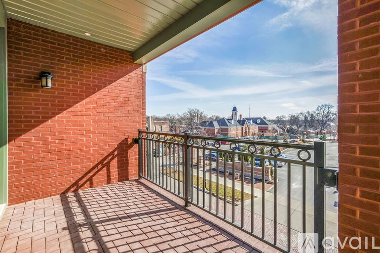 A balcony with a metal railing and brick steps leading up to it.
