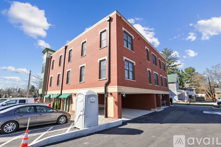 A red brick building with a parking lot in front.