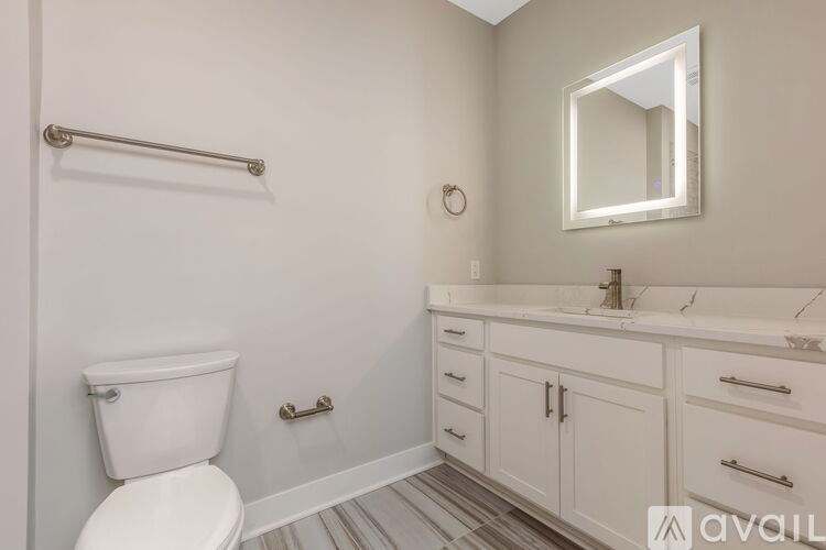 A white toilet sits next to a white sink in a bathroom.