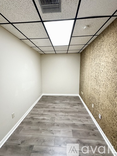 A room with a wooden floor and a ceiling with lights.