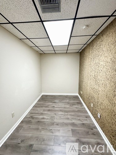 A room with a wooden floor and a ceiling with lights.