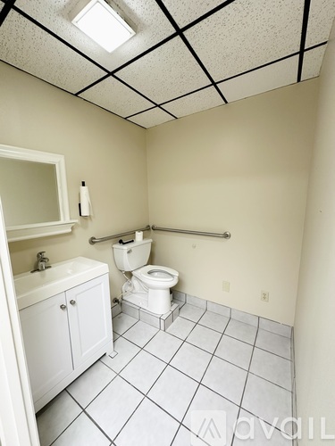 A small bathroom with a toilet, sink, and cabinet.