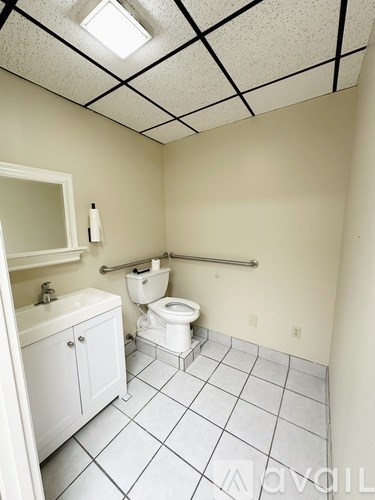 A small bathroom with a toilet, sink, and cabinet.