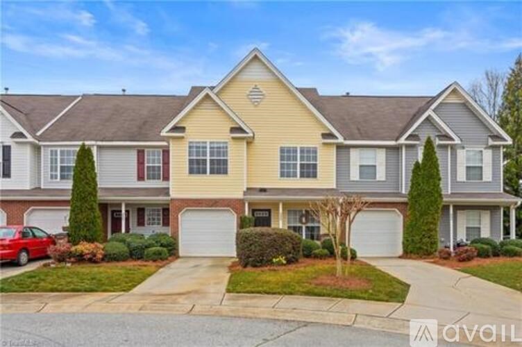 A two-story house with a red car parked in front.