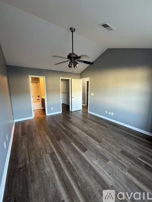 A room with a ceiling fan and wooden flooring.