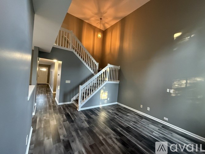 A staircase with a white railing leads to a second floor.