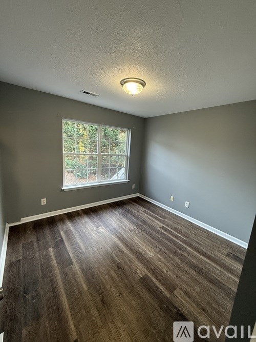 A room with wooden flooring and a window.