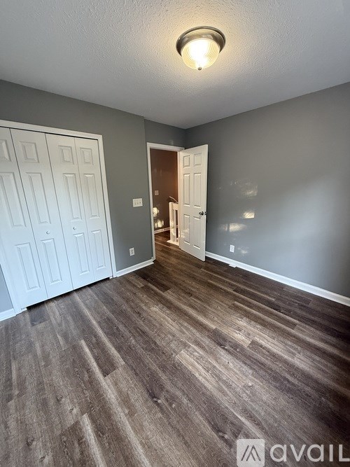 A room with a wooden floor and a white door.
