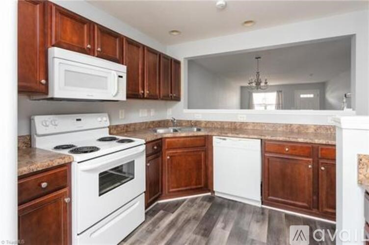 A kitchen with white appliances and wooden cabinets.