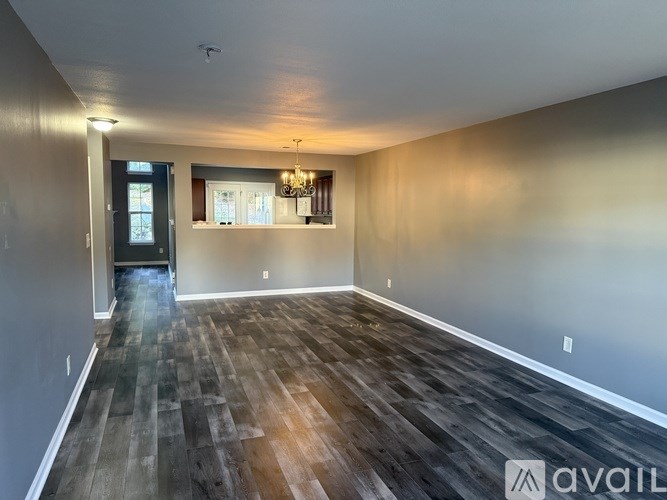 A room with wooden flooring and a chandelier.