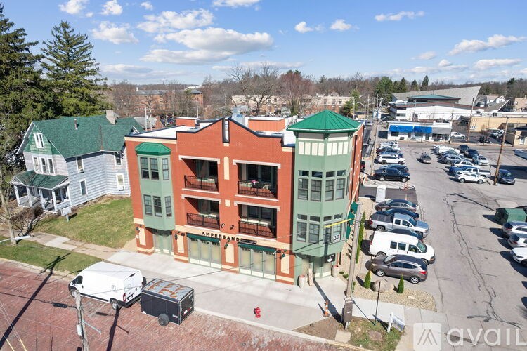A parking lot with cars and a building with a green roof.