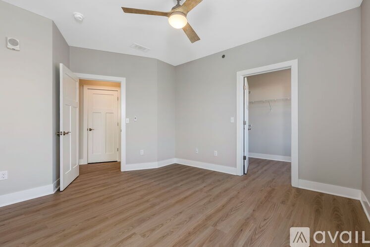 A room with a ceiling fan and wooden flooring.
