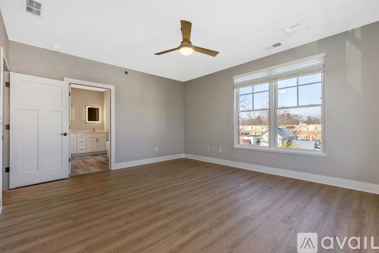 A room with a ceiling fan and a large window.